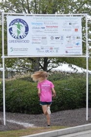 girls running under Race the Helix sponsor banner