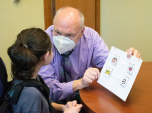 Physician wearing mask interacts with young girl
