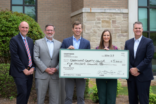 Five people holding large check for the GGC Foundation