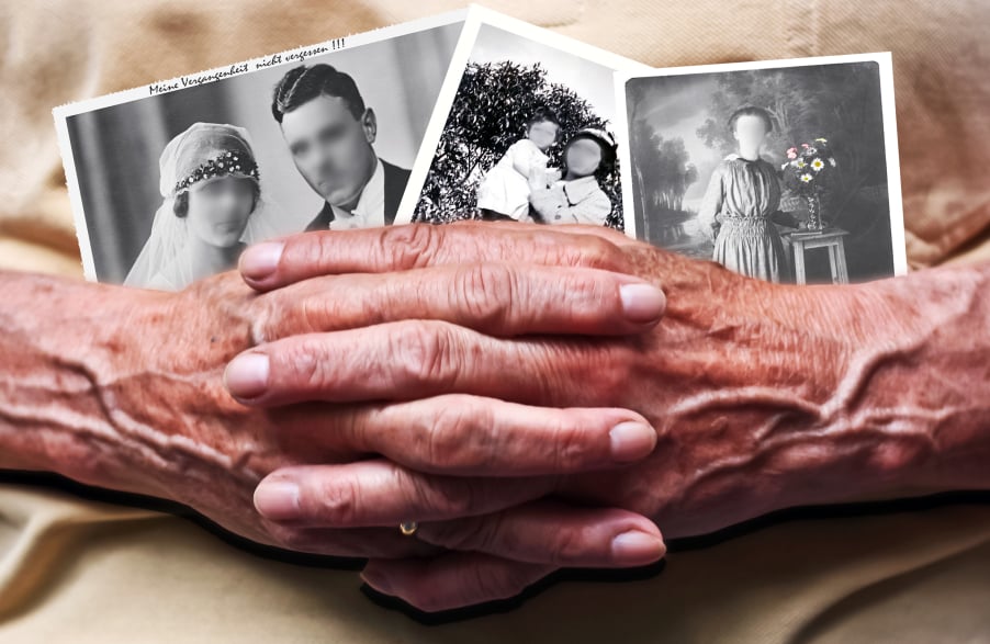elderly hands holding black and white photos