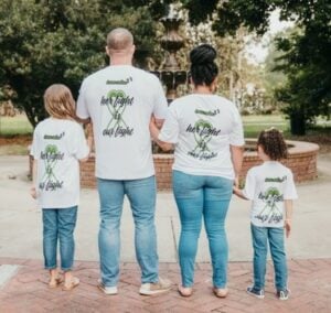 Parents and two children from behind with t-shirts that read Her fight is our fight
